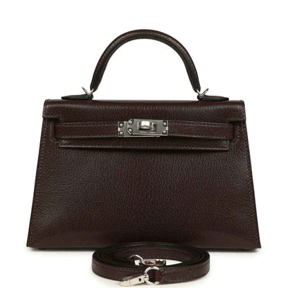 Small leather handbag with front flap, silver-tone clasp, and matching strap