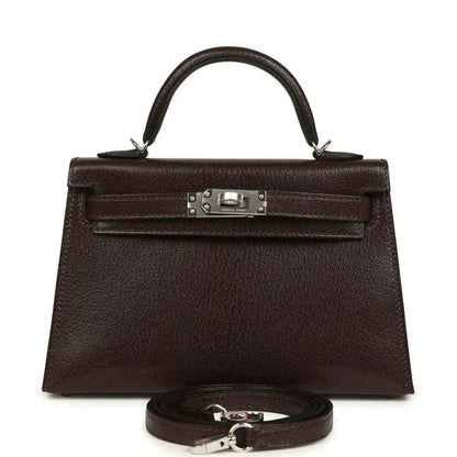 Small leather handbag with front flap, silver-tone clasp, and matching strap