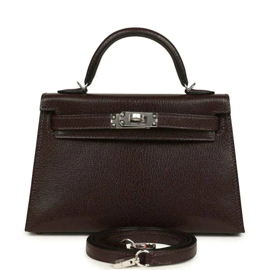 Small leather handbag with front flap, silver-tone clasp, and matching strap