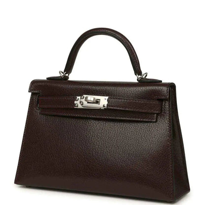 Small leather handbag angled front view with top handle and silver-tone clasp