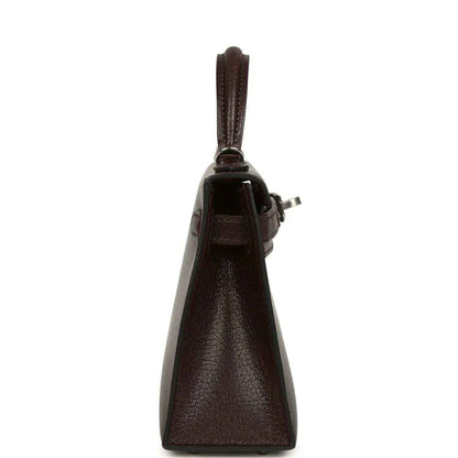 Small leather handbag side view with top handle and clasp hardware