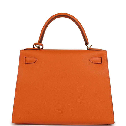 Orange leather Kelly bag with front flap pockets and top handle, front view.