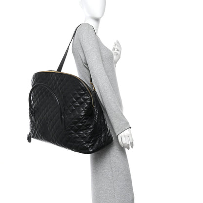 Saint Laurent ES quilted travel bag in black leather, side view with shoulder strap.