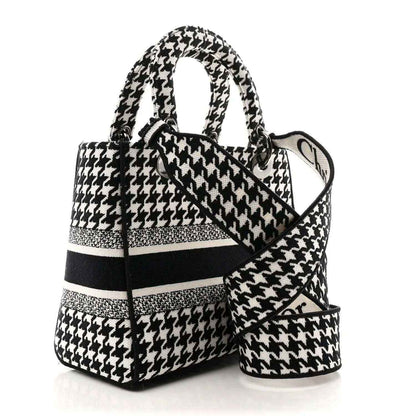Black-and-white houndstooth canvas bag with top handle and shoulder strap
