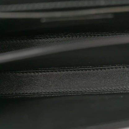 Black leather bag interior seam and textured lining detail.