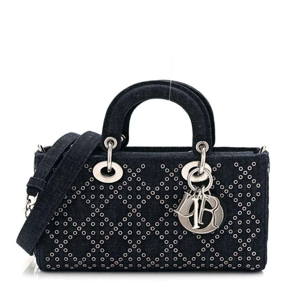 Denim eyelet handbag in dark blue with rolled handles, silver-tone rings, and charm