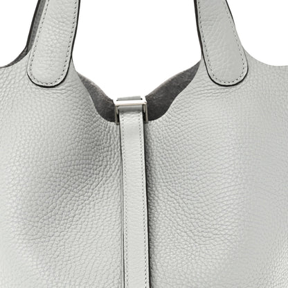 Close-up of light blue pebbled leather tote top with front lock and stitched edges