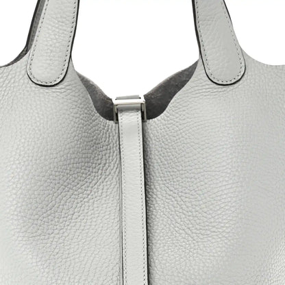 Close-up of light blue pebbled leather tote top with front lock and stitched edges