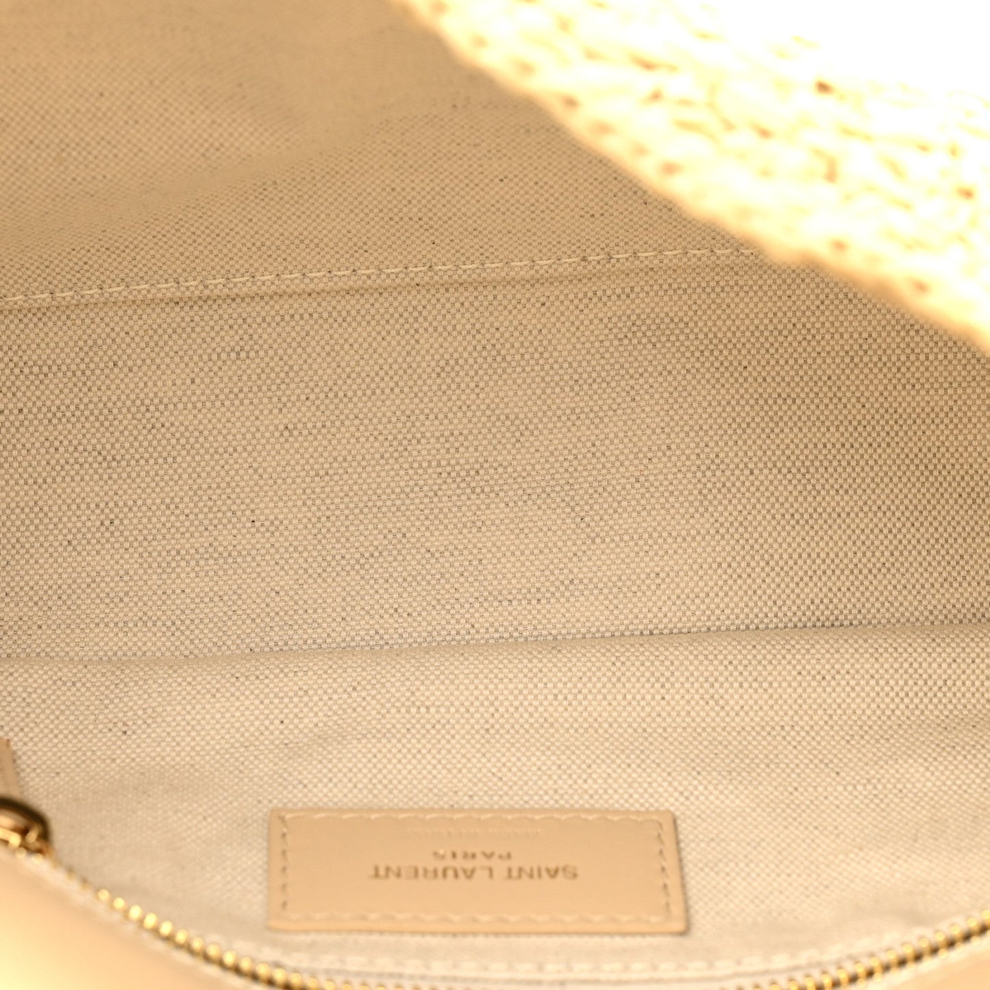 Beige fabric lining label with Saint Laurent Paris text and zipper seam