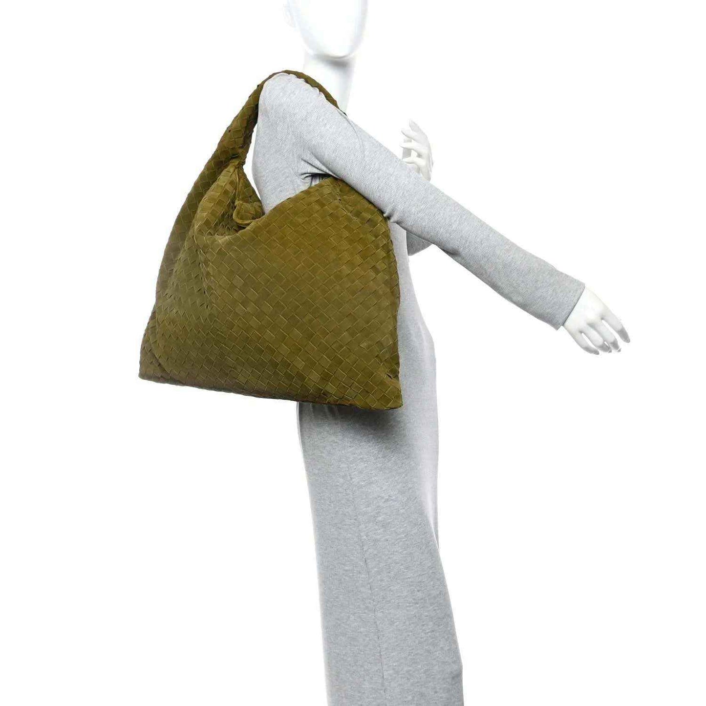 Olive suede intrecciato hobo bag held beside a model’s arm