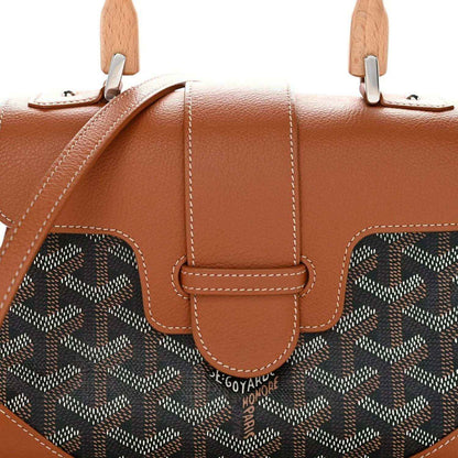 Mini shoulder bag front with tan leather flap and dark patterned canvas side panels