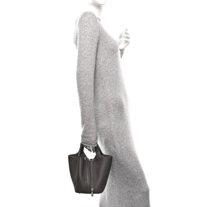 Dark brown leather tote bag with top handles and front lock closure, side view
