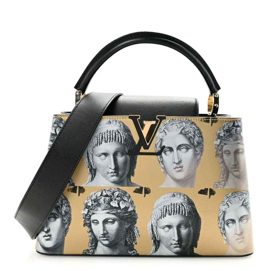 Capucines MM handbag with gold-tone hardware, black handles, and face-print front panel