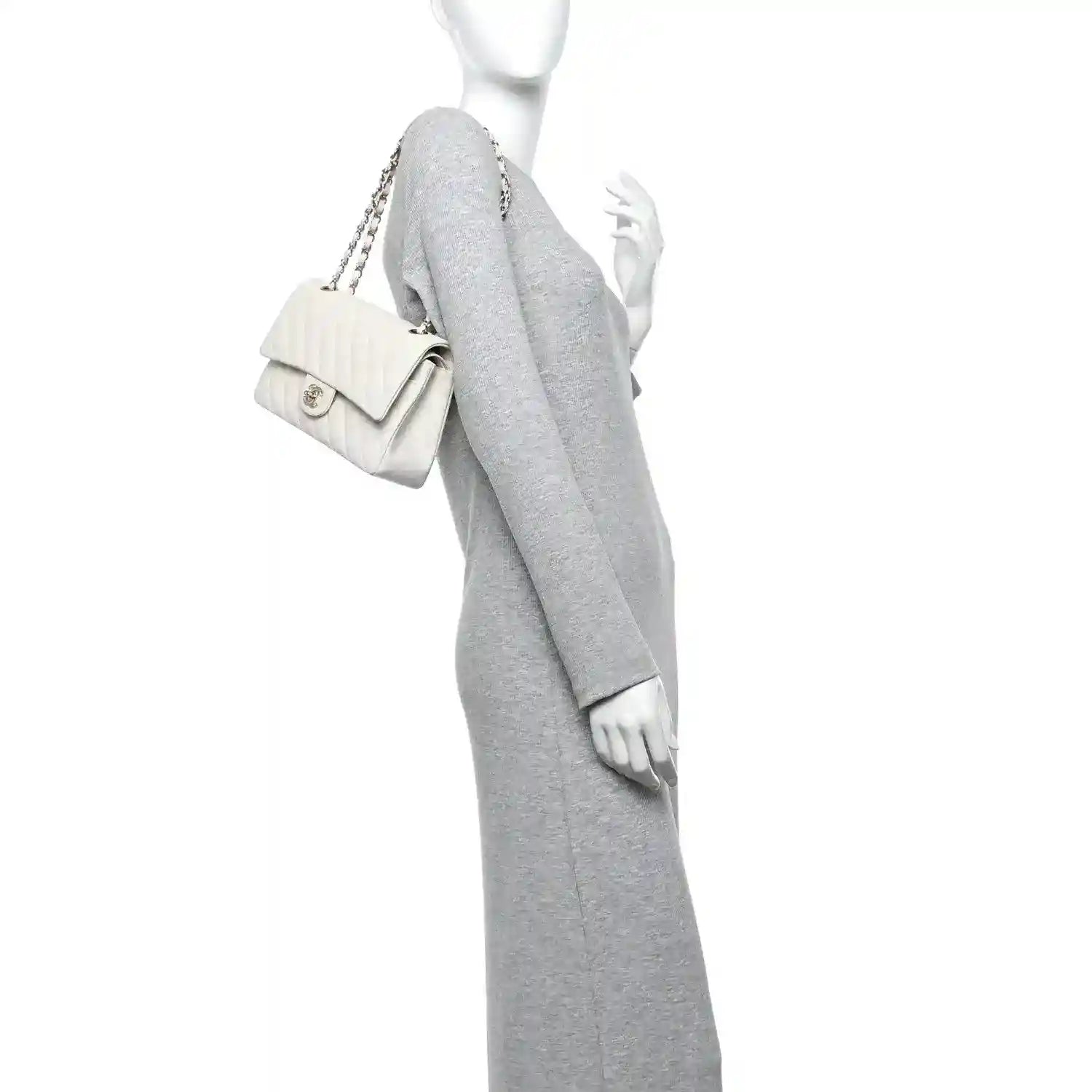 White quilted double flap bag with chain strap held by mannequin
