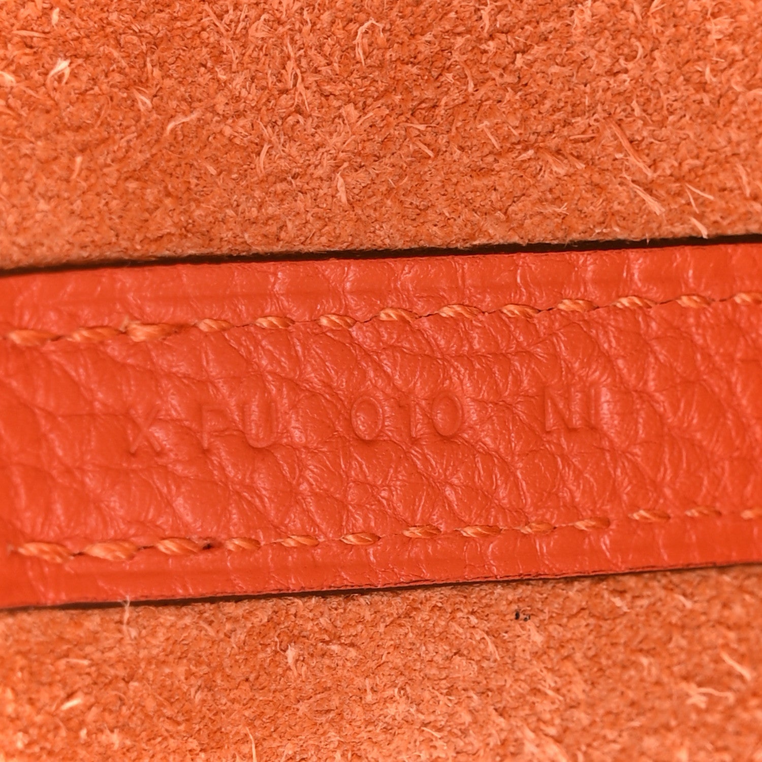 Orange leather handbag, close-up of textured surface
