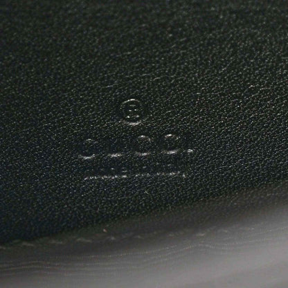 Close-up of embossed mark on black textured mini bag material