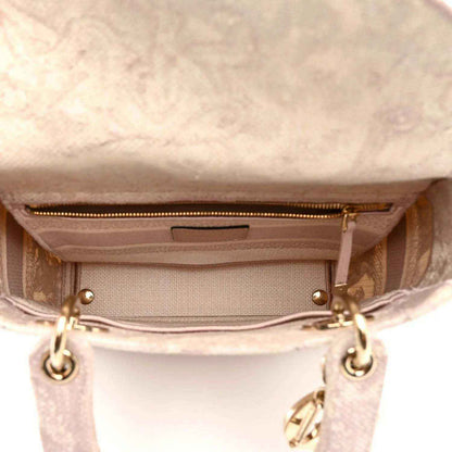 Rose-pink handbag interior view with top zipper and fabric lining, gold-tone hardware