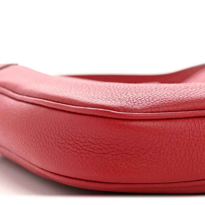Red pebbled leather hobo bag close-up of curved trim and textured grain
