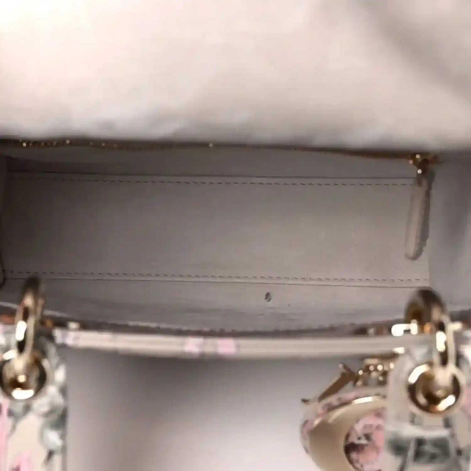 Handbag interior opening with stitched lining and metal ring hardware