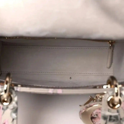 Handbag interior opening with stitched lining and metal ring hardware