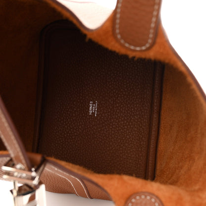Brown leather bucket tote bag interior with logo label and stitched trim