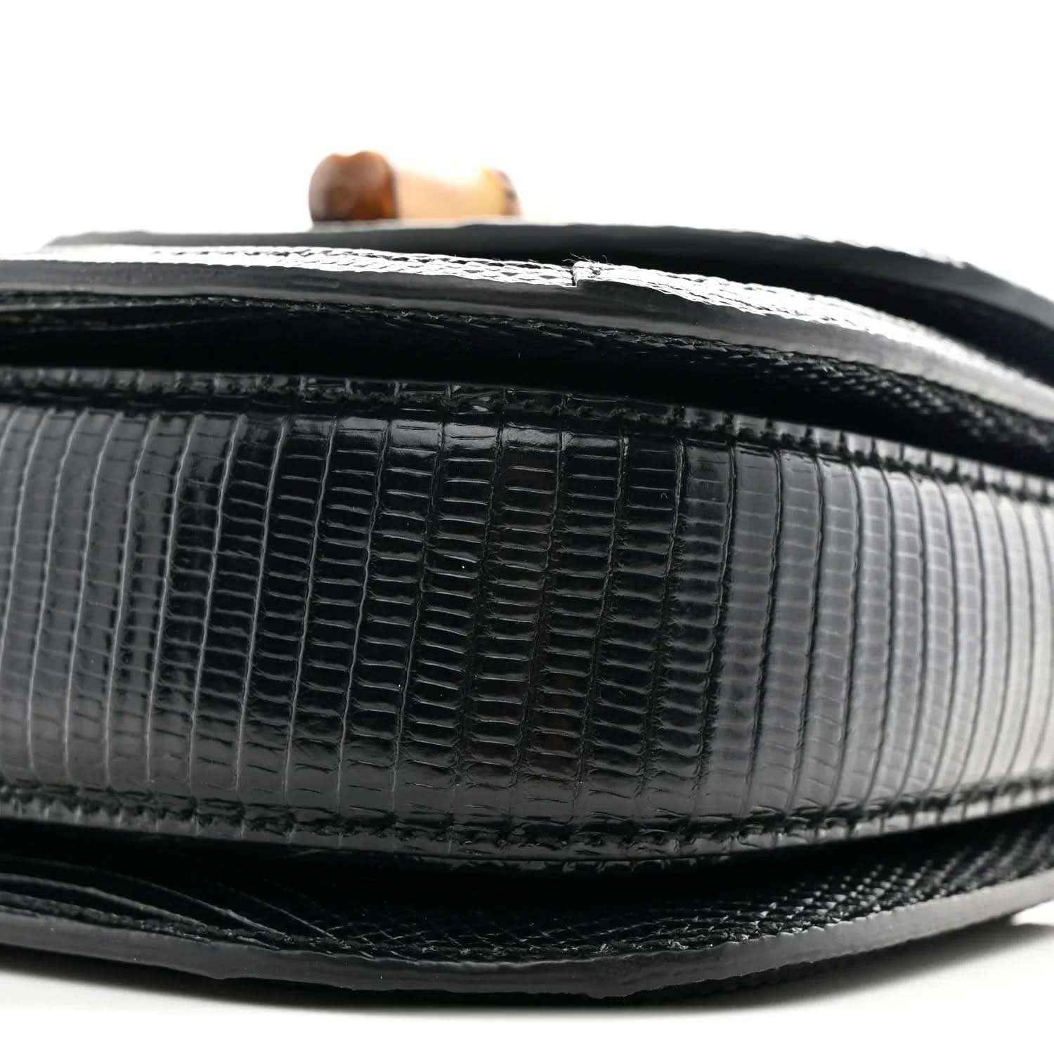 Close-up of black mini bag side with embossed grid texture and contrasting trim