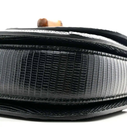 Close-up of black mini bag side with embossed grid texture and contrasting trim