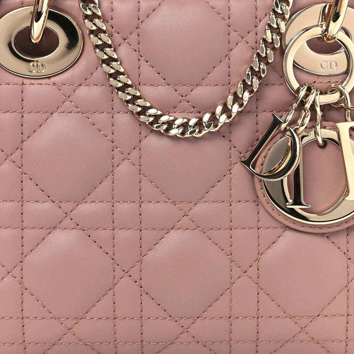 Mini Lady Dior handbag close-up: pink cannage quilting with gold-tone chain strap and charms.