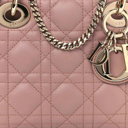 Mini Lady Dior handbag close-up: pink cannage quilting with gold-tone chain strap and charms.