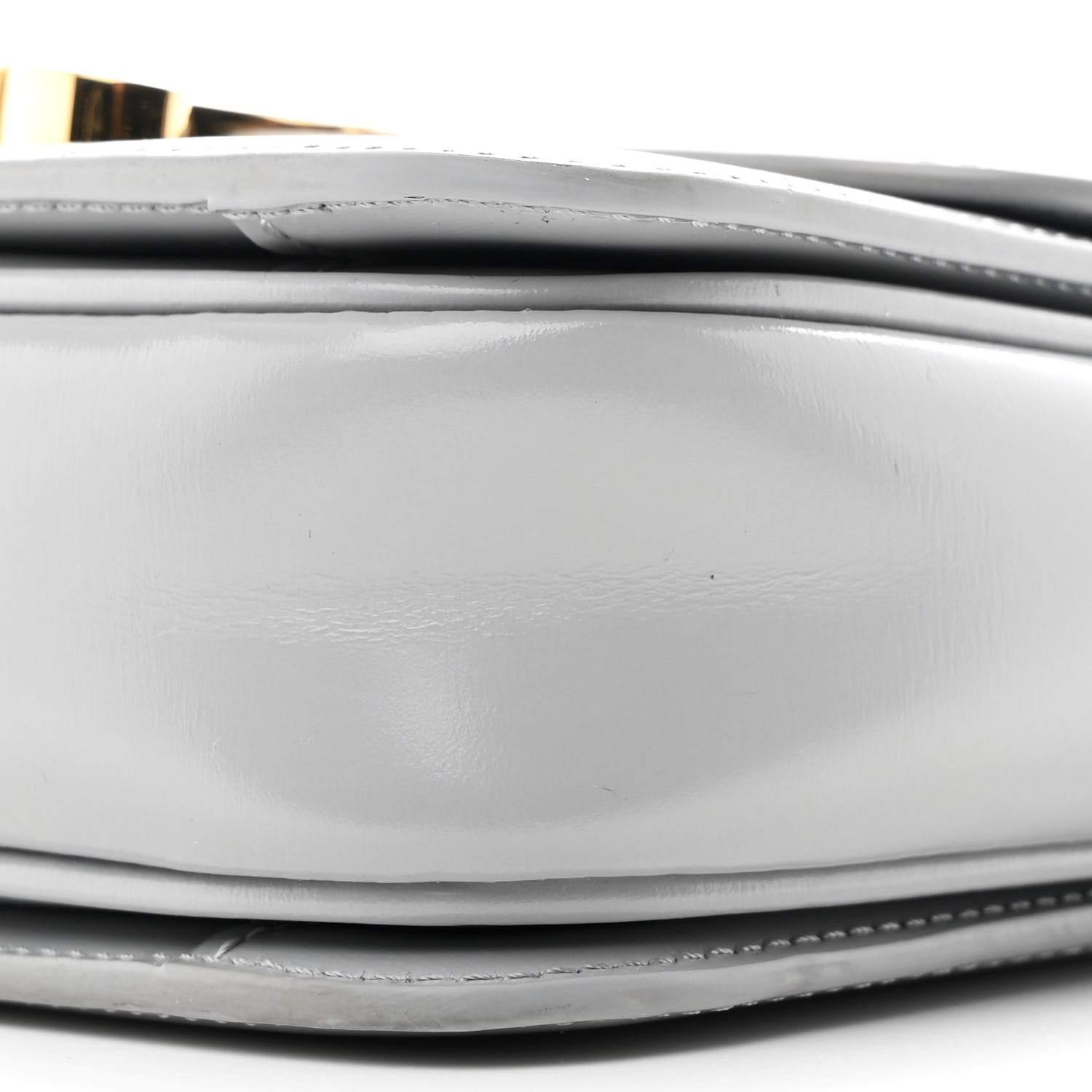 Shiny calfskin bag bottom edge with stitching and layered construction close-up
