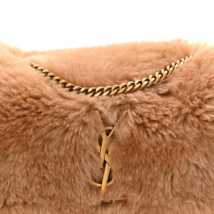 Saint Laurent reversible satchel with tan shearling, toggle closure, and gold chain