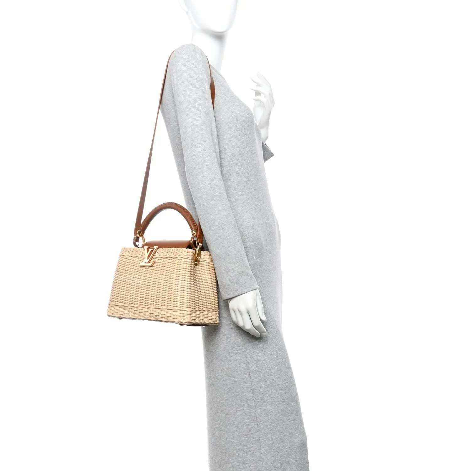Tan rattan handbag with brown leather strap, shown carried at side