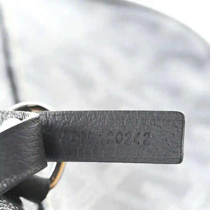 Grey leather strap with embossed text and stitching on Goyard hobo bag