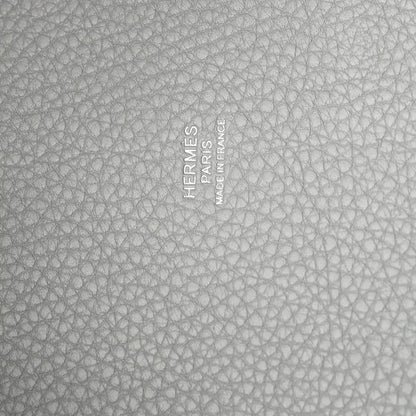Close-up of light blue pebbled leather with embossed stamp and text