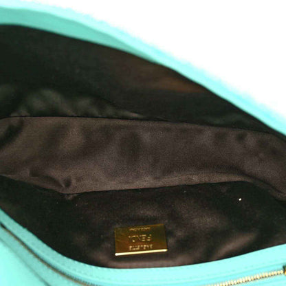 Turquoise leather-lined interior of sequin baguette bag with brand patch
