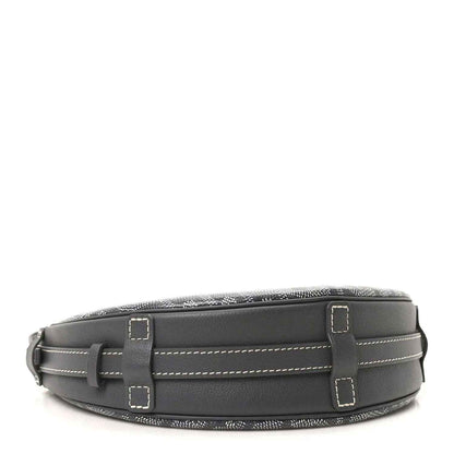 Dark leather shoulder bag with adjustable strap and rectangular buckle tabs