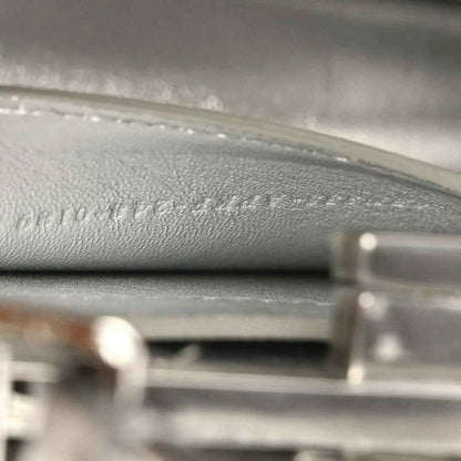 Interior leather lining with embossed text and stitched trim, silver tone hardware.