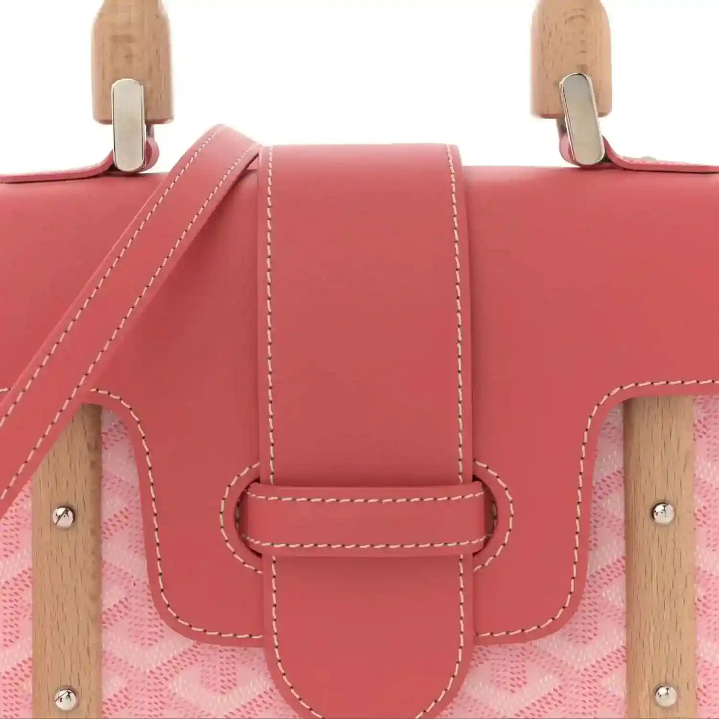 Pink bag front with wooden top handles and central leather clasp with double stitching.
