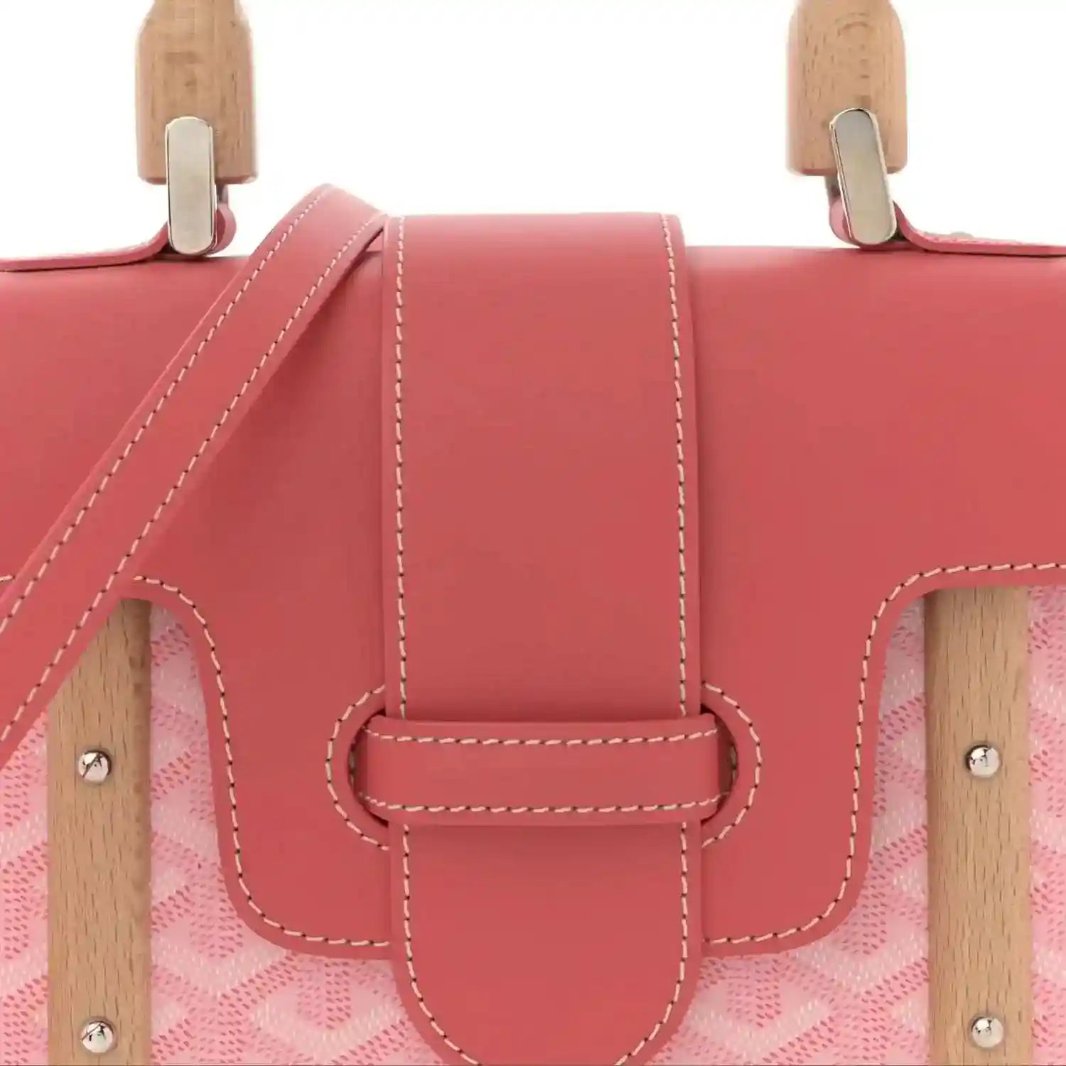 Pink bag front with wooden top handles and central leather clasp with double stitching.