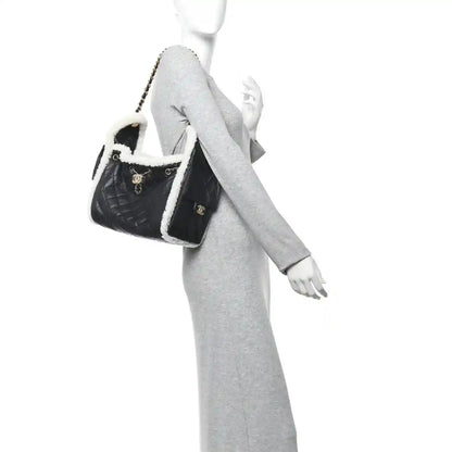Small Chanel quilted handbag in black with white shearling trim and chain strap