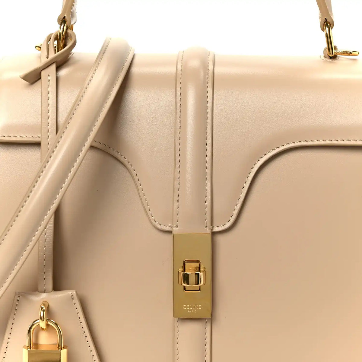 Nude small top-handle bag with gold buckle and leather strap close-up