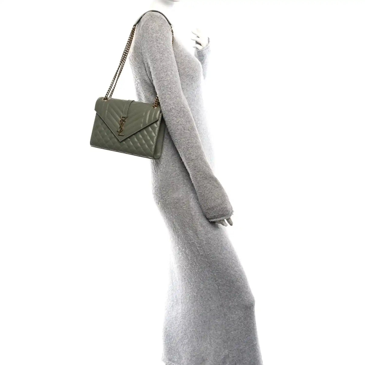 Light sage quilted satchel on shoulder with chain strap and flap closure