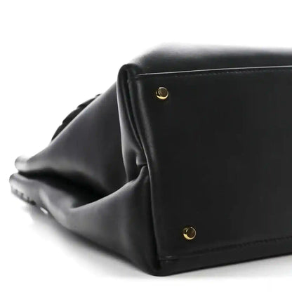 Black leather Ciao Ciao shoulder bag side view with gold button hardware and structured edge.