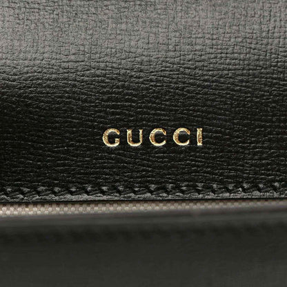 Black leather mini bag with gold GUCCI logo embossing on front panel