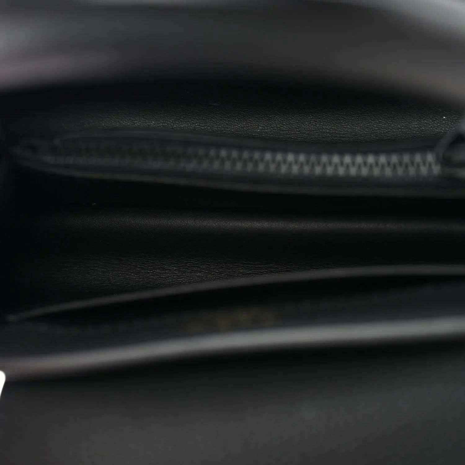 Black mini handbag interior close-up of zipper track and leather lining