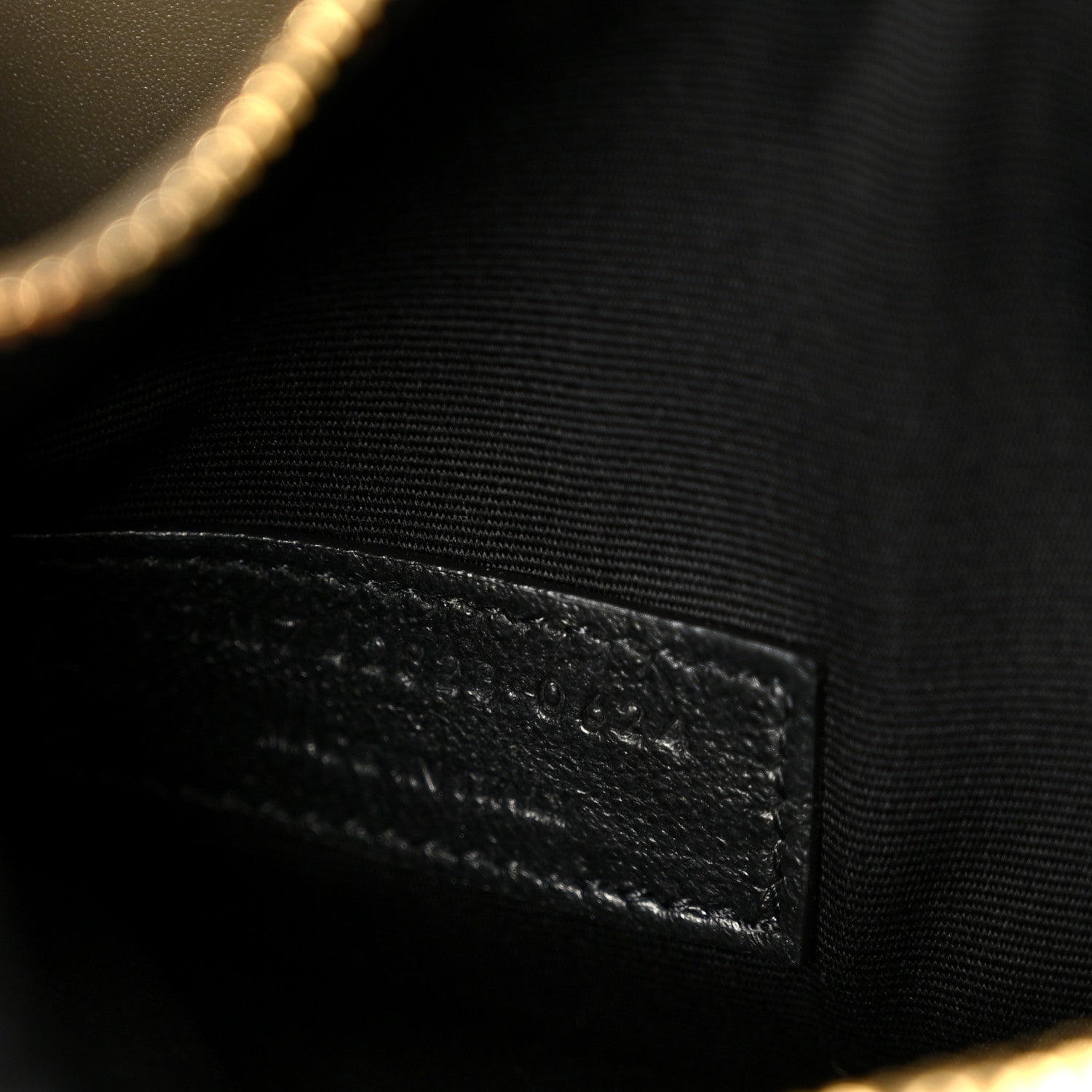 Saint Laurent interior lining detail with stitched leather edge in dark tone.