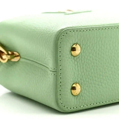 Louis Vuitton mini Capucines leather handbag, vert pomme green, close-up of gold snap hardware