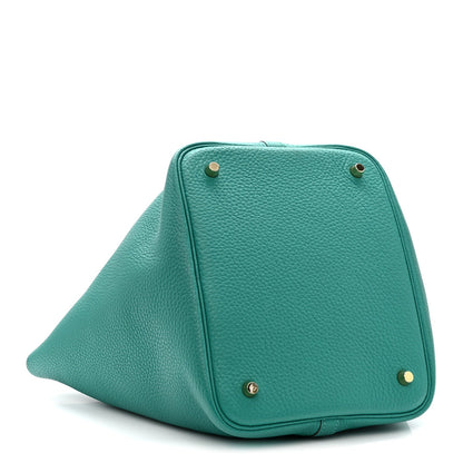 Green leather tote front with gold-tone corner studs and top lock closure