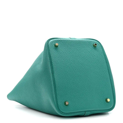 Green leather tote front with gold-tone corner studs and top lock closure