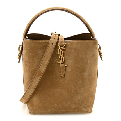 Suede bucket bag with top handles, adjustable strap, and YSL logo clasp, golden tan